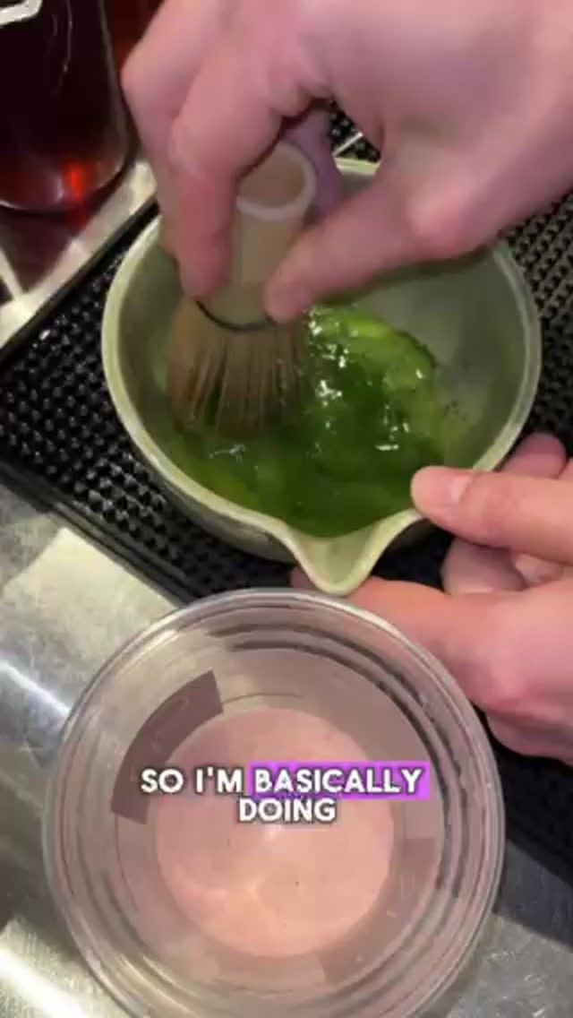 Hand-whisking matcha with a bamboo chasen in a ceramic bowl at CR Coffee Shop