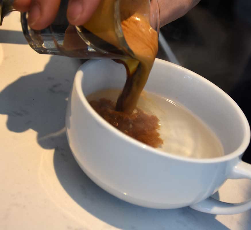 A fresh shot of espresso poured into an Americano