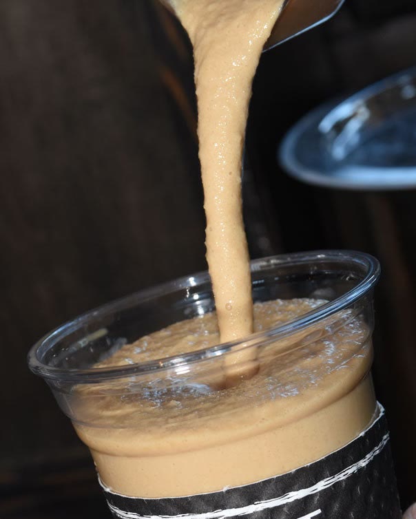 A thick Frozen Coffee pouring from the blender into the cup