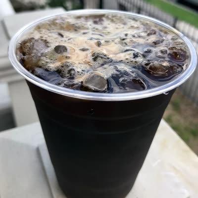 A Cold Brew Cubano in a clear cup, espresso crema settling over the cold brew