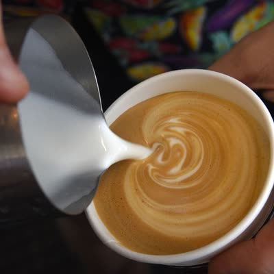 Steamed milk poured into a cortado in a small cup