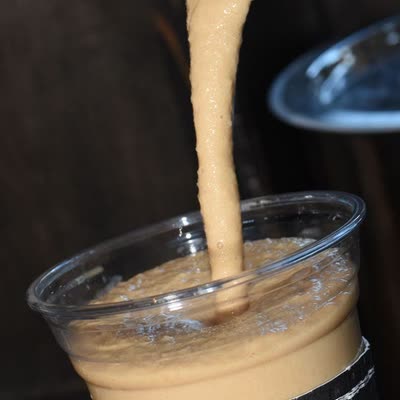 A Frozen Coffee in a clear cup with a straw