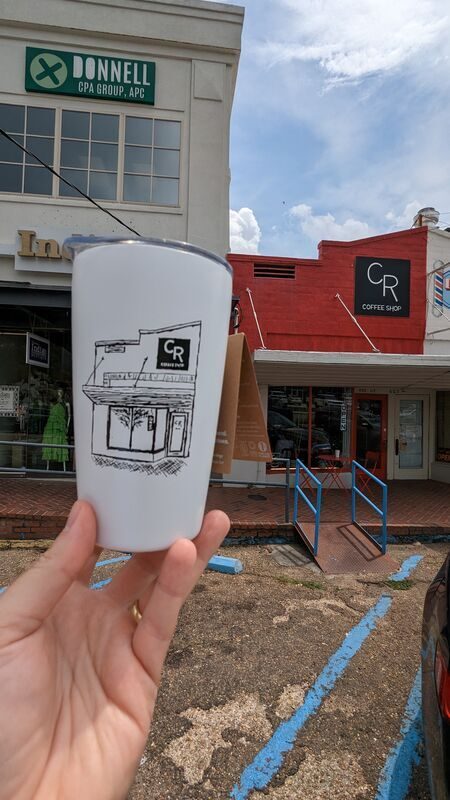 CR Coffee tumbler held outside the Old Metairie shop