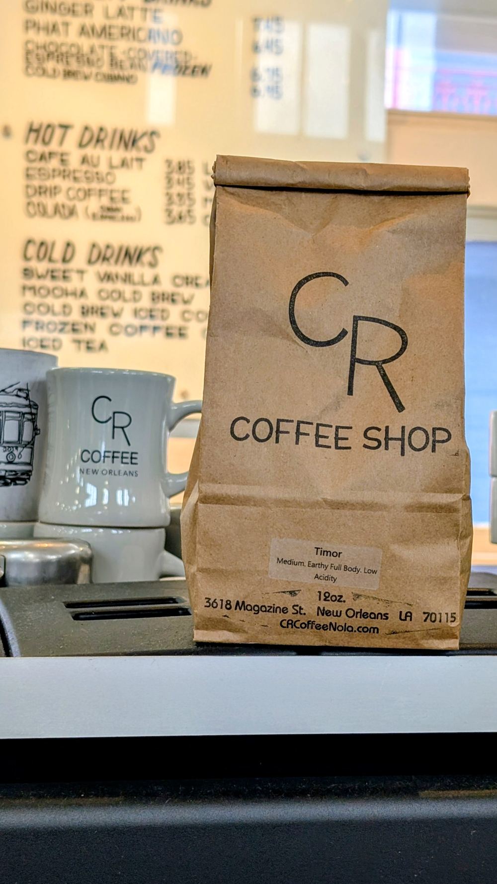 CR Coffee Shop 12-ounce Timor single origin coffee bag on the counter at Magazine Street, labeled medium, earthy full body, low acidity