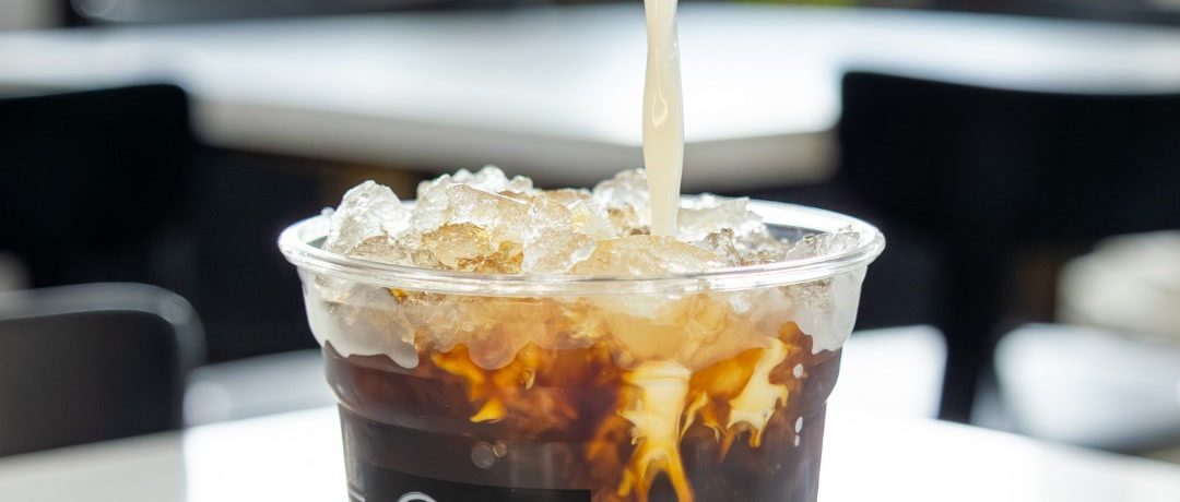 Iced coffee with cream being poured at CR Coffee Shop, brewed from beans roasted on antique Royal No. 6 drum roasters