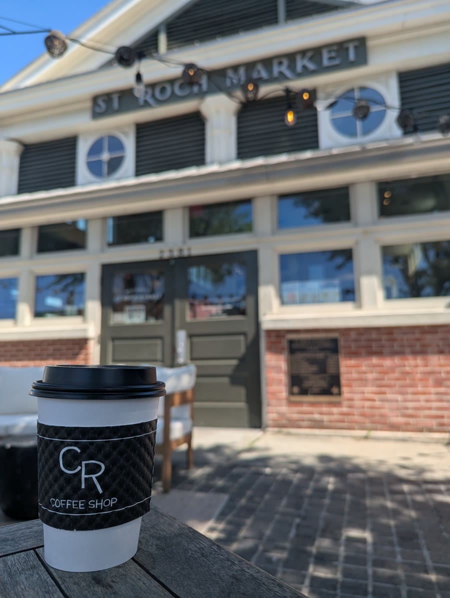 A CR Coffee cup on the sidewalk outside St. Roch Market